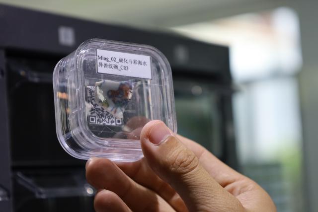 (260711) -- NANCHANG, July 11, 2026 (Xinhua) -- This file photo shows a staff member displaying a ceramic "gene" sample at Jingdezhen Imperial Kiln Institute in Jingdezhen, east China's Jiangxi Province. (Xinhua)