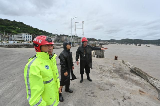 (260711) -- FUDING, July 11, 2026 (Xinhua) -- Village officials and rescuers patrol at a port in Shacheng Town of Fuding, southeast China's Fujian Province, July 11, 2026.
  Fujian has maintained its Level II typhoon emergency response and activated a Level III flood control emergency response as Typhoon Bavi nears China's east coast on Saturday.
 Local officials have implemented precautionary measures to prevent the Typhoon Bavi, including evacuating residents and inspecting geological hazard sites. Temporary shelters were fully stocked with supplies and medical resources. (Xinhua/Jiang Kehong)