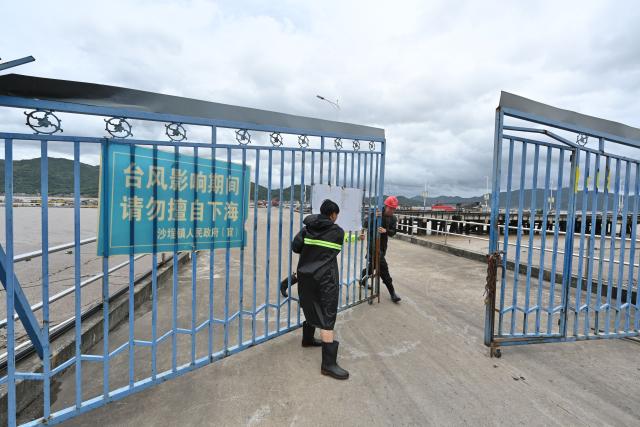 (260711) -- FUDING, July 11, 2026 (Xinhua) -- Staff members close the gate of a port in Shacheng Town of Fuding, southeast China's Fujian Province, July 11, 2026.
  Fujian has maintained its Level II typhoon emergency response and activated a Level III flood control emergency response as Typhoon Bavi nears China's east coast on Saturday.
 Local officials have implemented precautionary measures to prevent the Typhoon Bavi, including evacuating residents and inspecting geological hazard sites. Temporary shelters were fully stocked with supplies and medical resources. (Xinhua/Jiang Kehong)