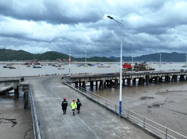 (260711) -- FUDING, July 11, 2026 (Xinhua) -- An aerial drone photo taken on July 11, 2026 shows village officials and rescuers patrolling at a port in Shacheng Town of Fuding, southeast China's Fujian Province.
  Fujian has maintained its Level II typhoon emergency response and activated a Level III flood control emergency response as Typhoon Bavi nears China's east coast on Saturday.
 Local officials have implemented precautionary measures to prevent the Typhoon Bavi, including evacuating residents and inspecting geological hazard sites. Temporary shelters were fully stocked with supplies and medical resources. (Xinhua/Jiang Kehong)