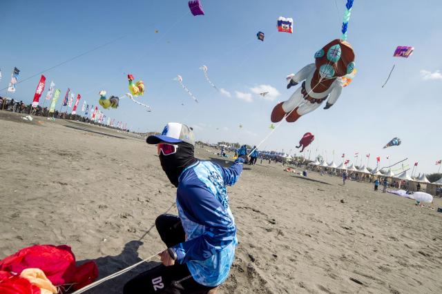 (260711) -- YOGYAKARTA, July 11, 2026 (Xinhua) -- A participant flies a kite during the Jogja International Kite Festival 2026 at Parangkusumo Beach in Yogyakarta, Indonesia, July 11, 2026. (Photo by Agung Supriyanto/Xinhua)