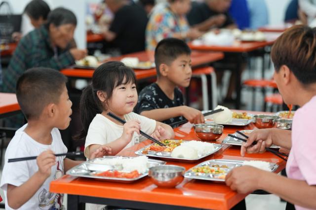 (260711) -- BEIJING, July 11, 2026 (Xinhua) -- People have lunch at a temporary shelter in Miyun District in Beijing, capital of China, July 11, 2026.
  Beijing is still under a Level II flood control emergency response as continuous heavy rainfall lashes the city, with eight of its districts activating the highest level flood response. As of Saturday morning, the city had evacuated 104,042 residents, shut down 181 tourist attractions and 4,311 rural homestays, with 27,418 rescue workers on standby to handle disasters such as mountain floods and landslides. (Xinhua/Ju Huanzong)