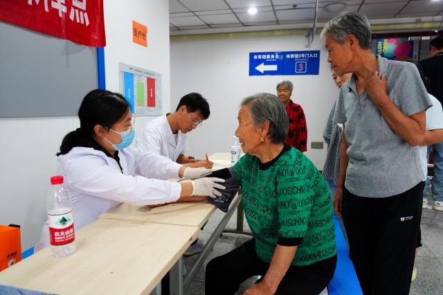 (260711) -- BEIJING, July 11, 2026 (Xinhua) -- A medical worker measures the blood pressure of an elderly resident at a temporary shelter in Pinggu District in Beijing, capital of China, July 11, 2026.
  Beijing is still under a Level II flood control emergency response as continuous heavy rainfall lashes the city, with eight of its districts activating the highest level flood response. As of Saturday morning, the city had evacuated 104,042 residents, shut down 181 tourist attractions and 4,311 rural homestays, with 27,418 rescue workers on standby to handle disasters such as mountain floods and landslides. (Xinhua/Xie Han)