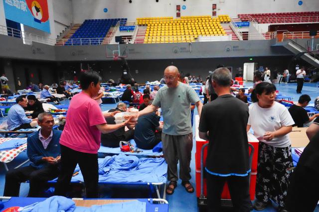 (260711) -- BEIJING, July 11, 2026 (Xinhua) -- People collect their lunch at a temporary shelter in Pinggu District in Beijing, capital of China, July 11, 2026.
  Beijing is still under a Level II flood control emergency response as continuous heavy rainfall lashes the city, with eight of its districts activating the highest level flood response. As of Saturday morning, the city had evacuated 104,042 residents, shut down 181 tourist attractions and 4,311 rural homestays, with 27,418 rescue workers on standby to handle disasters such as mountain floods and landslides. (Xinhua/Xie Han)
