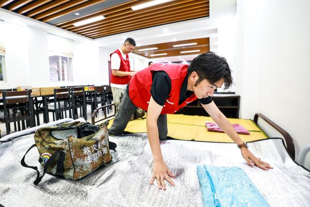 (260711) -- WENZHOU, July 11, 2026 (Xinhua) -- A volunteer makes beds at a temporary shelter, which hosts 20 local villagers affected by Typhoon Bavi, in Yongjia County of Wenzhou, east China's Zhejiang Province, July 10, 2026. Zhejiang Province in east China raised its typhoon emergency response to the highest level on Saturday as Typhoon Bavi, the 9th typhoon of 2026, barrels toward the country's eastern coast, triggering widespread disaster prevention efforts across multiple provincial-level regions. 
  According to Zhejiang Meteorological Observatory, the severe typhoon was located some 489 km off the coast of the province's city of Wenzhou as of 9 a.m. on Saturday, packing strong-typhoon-level winds near its center. It is forecast to move northwest at a speed of 30 to 35 km per hour and make landfall in Zhejiang around midnight. (Xinhua/Jiang Han)