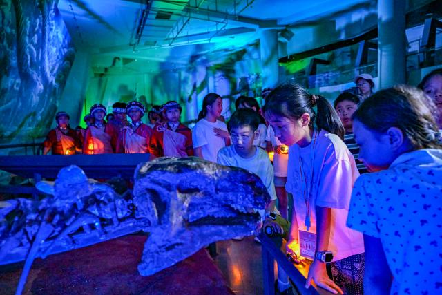 (260711) -- CHONGQING, July 11, 2026 (Xinhua) -- Kids from both sides of the Taiwan Strait participate in an event at the Chongqing Natural History Museum in southwest China's Chongqing Municipality, July 10, 2026. From July 9 to 12, young people from China's Taiwan and Chongqing participate in a series of cultural events in Chongqing. 
   A total of 40 kids attending these activities visited Chongqing Natural History Museum on Friday evening. They visited the dinosaur exhibition, learned about paleontology knowledge, played interactive games, built tents together and shared fun stories of their hometowns. The event helped the young people from both sides of the Taiwan Strait know each other better and build closer friendship. (Xinhua/Chen Shuo)