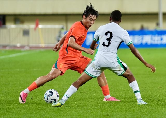 (260711) -- YINCHUAN, July 11, 2026 (Xinhua) -- Shuai Weihao (L) of China competes during the CFA Team China International Youth Football Tournament Yinchuan 2026 between Chinese U17 national team and Nigerian U17 national team in Yinchuan, northwest China's Ningxia Hui Autonomous Region, July 11, 2026. (Xinhua/Yang Zhisen)