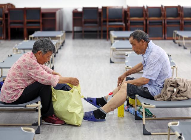 (260711) -- BEIJING, July 11, 2026 (Xinhua) -- An elderly couple arrange belongings at a shelter in Jinshan District of east China's Shanghai, on July 11, 2026. Chinese authorities on Saturday intensified emergency response measures with Typhoon Bavi set to slam into the country's eastern coast, resulting in meteorological, water resources, transport and emergency management authorities issuing alerts and reinforcing flood-control efforts ahead of the expected landfall.
   The country's State Flood Control and Drought Relief Headquarters activated a Level-IV emergency response for flood and typhoon control in Shanghai, Jiangsu, Anhui and Jiangxi, all in east China, as well as southwest China's Sichuan Province, according to the Ministry of Emergency Management. (Xinhua/Liu Ying)