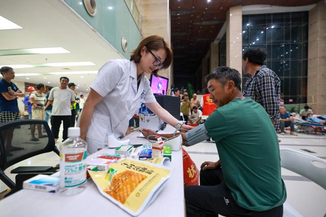 (260711) -- BEIJING, July 11, 2026 (Xinhua) -- A medical worker measures blood pressure for a resident at a shelter in Yueqing City, east China's Zhejiang Province, on July 11, 2026. Chinese authorities on Saturday intensified emergency response measures with Typhoon Bavi set to slam into the country's eastern coast, resulting in meteorological, water resources, transport and emergency management authorities issuing alerts and reinforcing flood-control efforts ahead of the expected landfall.
   The country's State Flood Control and Drought Relief Headquarters activated a Level-IV emergency response for flood and typhoon control in Shanghai, Jiangsu, Anhui and Jiangxi, all in east China, as well as southwest China's Sichuan Province, according to the Ministry of Emergency Management. (Xinhua/Jiang Han)
