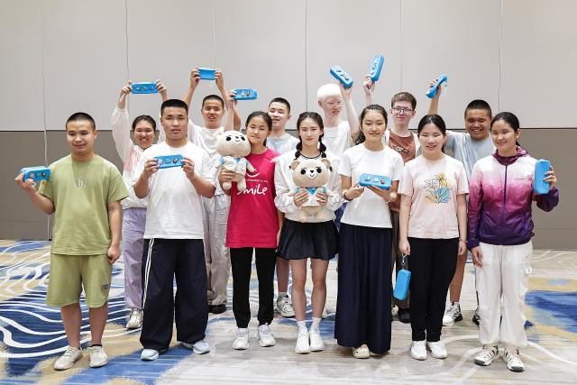 (260713) -- BEIJING, July 13, 2026 (Xinhua) -- World diving gold medalist Chen Yuxi (C, front) poses for a group photo with children during a summer camp event in Beijing, capital of China, July 12, 2026.
  The UN Children's Fund (UNICEF) China on Sunday invited world diving gold medalist Chen Yuxi to a summer camp event here attended by children with visual impairments, in an effort to help children with disabilities discover their potential and raise public awareness of protecting their rights. (Xinhua/Zhang Yuwei)