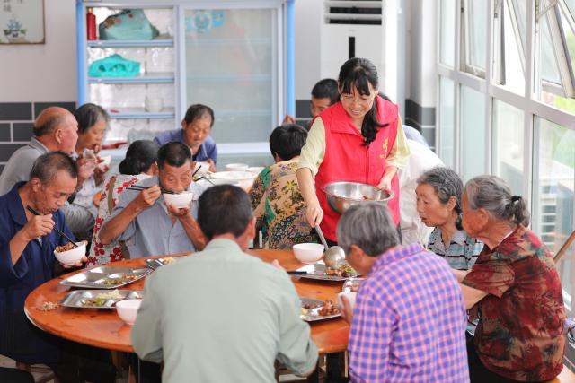 (260713) -- BEIJING, July 13, 2026 (Xinhua) -- A volunteer serves lunch for relocated people at a temporary shelter in Yanggan Village of Huangshan City, east China's Anhui Province, July 12, 2026.
  As extreme weather has battered multiple regions across China in recent days, local authorities have implemented disaster prevention and relief measures to safeguard people's lives and property. (Photo by Fan Chengzhu/Xinhua)