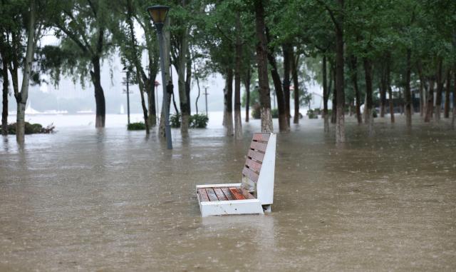 (260713) -- SHENYANG, July 13, 2026 (Xinhua) -- This photo taken on July 13, 2026 shows the bank of the Hunhe River inundated by floodwaters in Shenyang, northeast China's Liaoning Province. Due to recent downpours, the water level at the Shenyang Hydrological Station on the Hunhe River reached 37.99 meters. (Xinhua/Yang Qing)