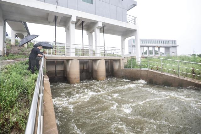 (260713) -- BEIJING, July 13, 2026 (Xinhua) -- Staff members check a pump-and-sluice station along Taiping River in Panjin City, northeast China's Liaoning Province, July 13, 2026. As extreme weather has swept across multiple regions across China in recent days, local authorities have implemented disaster prevention and relief measures to safeguard people's lives and property. (Xinhua/Pan Yulong)