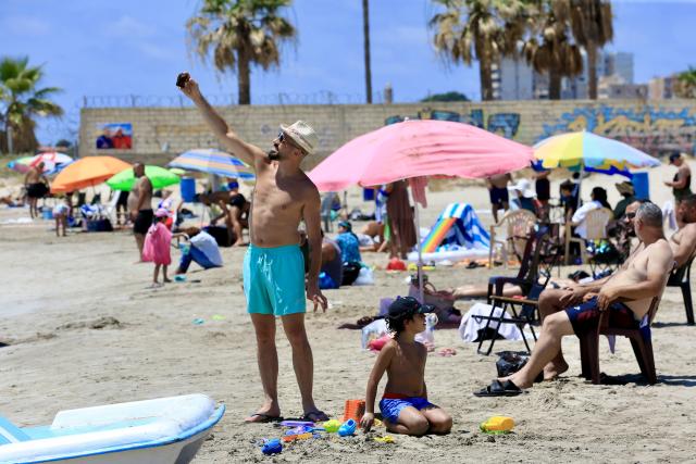 (260713) -- TYRE, July 13, 2026 (Xinhua) -- People enjoy themselves on a beach in Tyre, Lebanon, July 12, 2026. (Photo by Ali Hashisho/Xinhua)