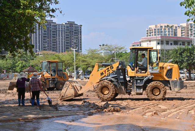 (260713) -- GUIGANG, July 13, 2026 (Xinhua) -- Staff members remove sludge in Guigang City, south China's Guangxi Zhuang Autonomous Region, July 13, 2026. As Typhoon Maysak recedes, Guigang City has initiated efforts to pump out water, clear sludge, and restore power supply, striving to bring people's production and daily life back to normal. (Xinhua/Lu Boan)