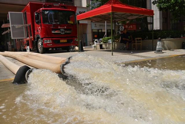 (260713) -- GUIGANG, July 13, 2026 (Xinhua) -- Water is pumped out at a community in Guigang City, south China's Guangxi Zhuang Autonomous Region, July 13, 2026. As Typhoon Maysak recedes, Guigang City has initiated efforts to pump out water, clear sludge, and restore power supply, striving to bring people's production and daily life back to normal. (Xinhua/Lu Boan)