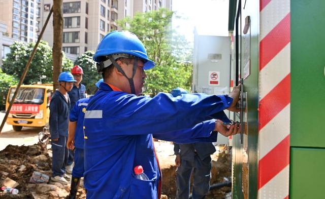 (260713) -- GUIGANG, July 13, 2026 (Xinhua) -- Staff members restore power supply at a community in Guigang City, south China's Guangxi Zhuang Autonomous Region, July 13, 2026. As Typhoon Maysak recedes, Guigang City has initiated efforts to pump out water, clear sludge, and restore power supply, striving to bring people's production and daily life back to normal. (Xinhua/Lu Boan)