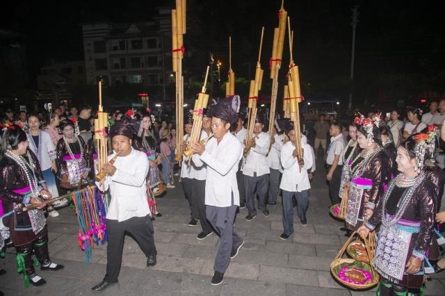 (260713) -- CONGJIANG, July 13, 2026 (Xinhua) -- People of the Dong ethnic group perform Lusheng, a reed-pipe wind instrument, during a musical event in Congjiang County of southwest China's Guizhou Province, July 12, 2026. The event featuring performing arts of the Dong ethnic group and local specialty foods was held here on Sunday, attracting hundreds of tourists. (Photo by Wu Dejun/Xinhua)