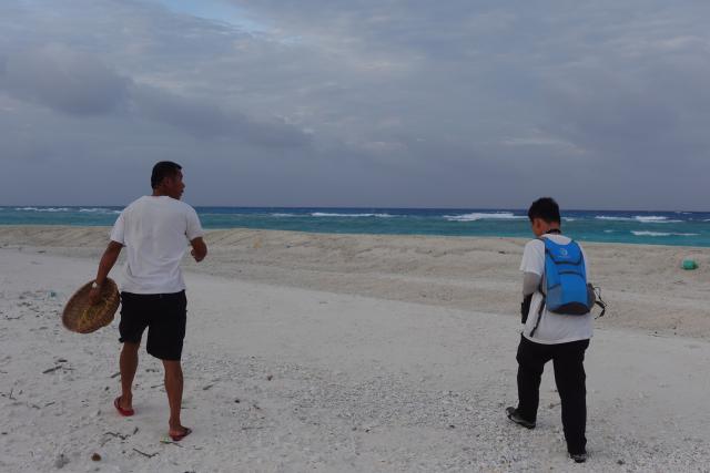 (260713) -- HAIKOU, July 13, 2026 (Xinhua) -- A researcher (R) and a fisherman patrol at the Qilianyu Islands in the Xisha Islands, the South China Sea, June 20, 2026. TO GO WITH "Feature: How researchers, locals safeguard ecological harmony in China's Xisha Islands" (Xinhua)