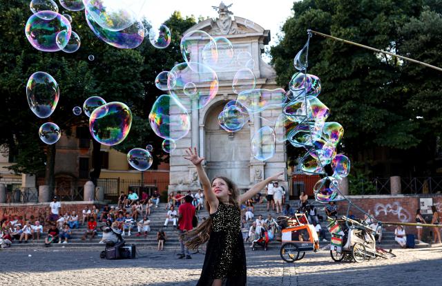 (260714) -- BEIJING, July 14, 2026 (Xinhua) -- A girl plays with bubbles on a square along the Tiber River in Rome, Italy, July 12, 2026. The 24th edition of "Along the Tiber Rome" event is held here along the banks of the Tiber and will run until the end of August. It has become a popular summer event featuring culture, music and gastronomy. (Xinhua/Wang Kaiyan)