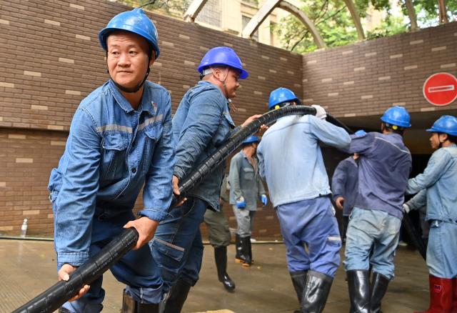 (260714) -- GUIGANG, July 14, 2026 (Xinhua) -- Staff members perform emergency repairing at a residential compound in Guigang City, south China's Guangxi Zhuang Autonomous Region, July 14, 2026. The power supplier in Guigang has mobilized all hands available to restore power supply as flooding inflicted by typhoon Maysak subsides in the city. (Xinhua/Lu Boan)