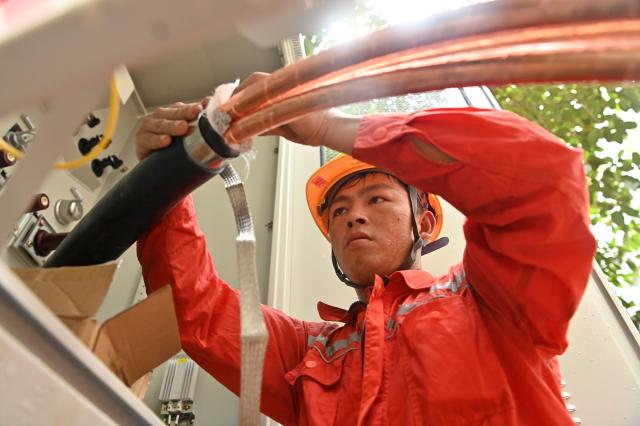 (260714) -- GUIGANG, July 14, 2026 (Xinhua) -- A staff member performs emergency repairing at a residential compound in Guigang City, south China's Guangxi Zhuang Autonomous Region, July 14, 2026. The power supplier in Guigang has mobilized all hands available to restore power supply as flooding inflicted by typhoon Maysak subsides in the city. (Xinhua/Lu Boan)