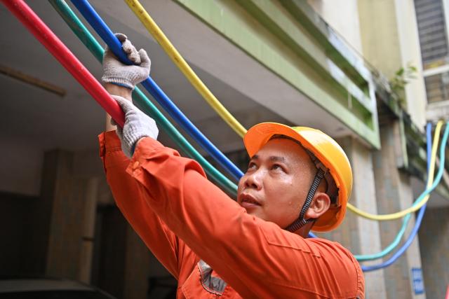 (260714) -- GUIGANG, July 14, 2026 (Xinhua) -- A staff member performs emergency repairing at a residential compound in Guigang City, south China's Guangxi Zhuang Autonomous Region, July 14, 2026. The power supplier in Guigang has mobilized all hands available to restore power supply as flooding inflicted by typhoon Maysak subsides in the city. (Xinhua/Lu Boan)