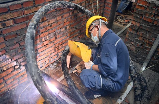 (260714) -- GUIGANG, July 14, 2026 (Xinhua) -- A staff member performs emergency repairing at a residential compound in Guigang City, south China's Guangxi Zhuang Autonomous Region, July 14, 2026. The power supplier in Guigang has mobilized all hands available to restore power supply as flooding inflicted by typhoon Maysak subsides in the city. (Xinhua/Lu Boan)