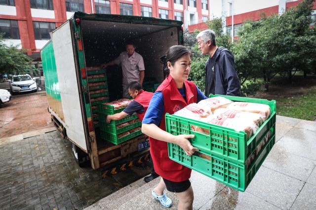 (260714) -- SHENYANG, July 14, 2026 (Xinhua) -- Staff members transfer supplies at a temporary relocation in Shenyang, northeast China's Liaoning Province, July 14, 2026. Recently, heavy rainfall has caused flooding in parts of Liaoning Province. Local officials have worked on the front line to evacuate residents and provide them with temporary relocation. (Xinhua/Pan Yulong)