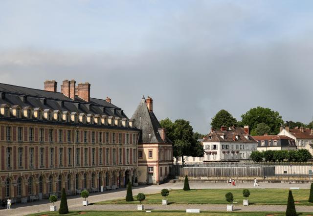 (260714) -- SEINE-ET-MARNE, July 14, 2026 (Xinhua) -- Tourists visit the Palace of Fontainebleau in Seine-et-Marne, France, as smoke from a wildfire is seen in the distance, on July 14, 2026. French police have detained 59 people across the country in connection with wildfires, including two suspects linked to the blaze in the Fontainebleau forest in Seine-et-Marne department, southeast of Paris, French Interior Minister Laurent Nunez said on Monday.
   The wildfire in the Fontainebleau forest broke out on Sunday evening and continued to spread on Monday. (Xinhua/Wu Huiwo)