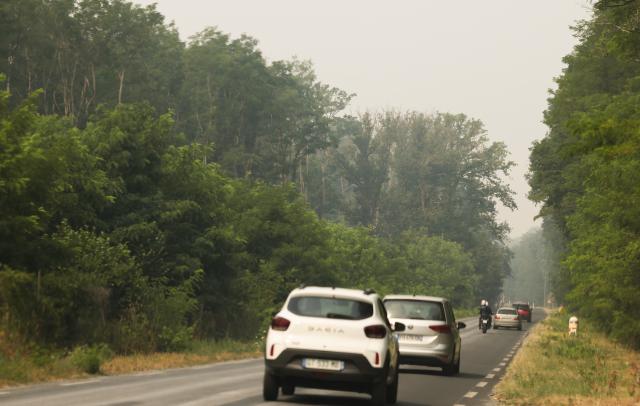 (260714) -- SEINE-ET-MARNE, July 14, 2026 (Xinhua) -- Vehicles travel along a road shrouded in smoke from a wildfire in Seine-et-Marne, France, on July 14, 2026. French police have detained 59 people across the country in connection with wildfires, including two suspects linked to the blaze in the Fontainebleau forest in Seine-et-Marne department, southeast of Paris, French Interior Minister Laurent Nunez said on Monday.
   The wildfire in the Fontainebleau forest broke out on Sunday evening and continued to spread on Monday. (Xinhua/Wu Huiwo)