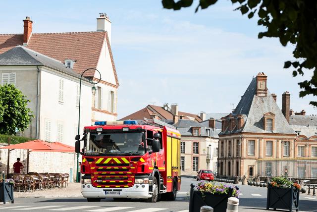 (260714) -- SEINE-ET-MARNE, July 14, 2026 (Xinhua) -- A fire truck passes in front of the Palace of Fontainebleau in Seine-et-Marne, France, on July 14, 2026. French police have detained 59 people across the country in connection with wildfires, including two suspects linked to the blaze in the Fontainebleau forest in Seine-et-Marne department, southeast of Paris, French Interior Minister Laurent Nunez said on Monday.
   The wildfire in the Fontainebleau forest broke out on Sunday evening and continued to spread on Monday. (Xinhua/Wu Huiwo)
