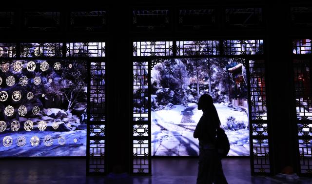 (260714) -- BEIJING, July 14, 2026 (Xinhua) -- A visitor is pictured during "A Garden Within: An Immersive Light and Shadow Exhibition of the Qianlong Garden" at National Museum of Classic Books in Beijing, capital of China, July 14, 2026. The exhibition, which features multiple immersive scenarios and interactive installations, is held here from July 9 to Dec. 6.
   The Qianlong Garden, also known as the Garden of the Palace of Tranquil Longevity, was built by Emperor Qianlong (1711-1799) of Qing Dynasty (1644-1911) as a private retreat for his later years in the Forbidden City, or today's Palace Museum. (Xinhua/Yin Gang)
