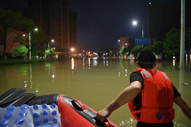 (260714) -- NANNING, July 14, 2026 (Xinhua) -- A volunteer hauls relief supplies on a waterlogged road in Guigang City, south China's Guangxi Zhuang Autonomous Region, July 9, 2026. Efforts are underway to support flood relief and recovery in Guangxi, which has been hit by severe rainstorms and flooding caused by Typhoon Maysak. (Xinhua/Zhou Hua)