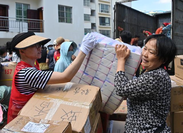 (260714) -- NANNING, July 14, 2026 (Xinhua) -- Volunteers transfer relief supplies at a charity federation in Nanning, south China's Guangxi Zhuang Autonomous Region, July 12, 2026. Efforts are underway to support flood relief and recovery in Guangxi, which has been hit by severe rainstorms and flooding caused by Typhoon Maysak. (Xinhua/Lu Boan)