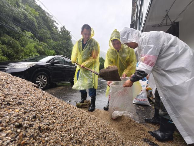 (260714) -- BEIJING, July 14, 2026 (Xinhua) -- This photo taken with a mobile phone shows staff members preparing sandbags in Tianmushan Town, Lin'an District of Hangzhou City, east China's Zhejiang Province, July 12, 2026. Torrential rain has caused flooding in multiple places in China recently. In rescue across the country, rescuers have risen to the occasion to protect the people. (Photo by Hu Jianhuan/Xinhua)