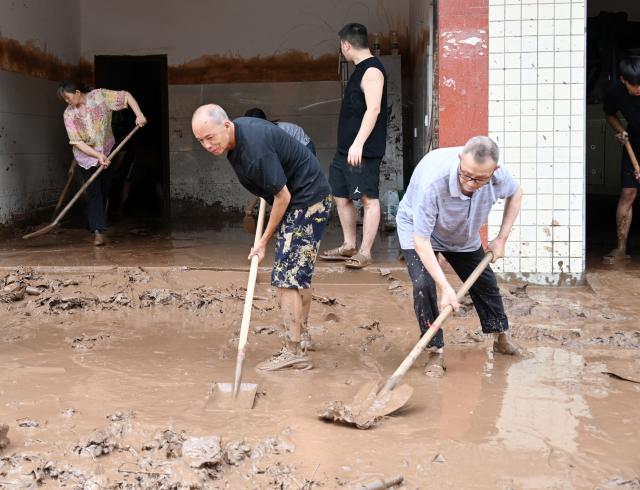 (260714) -- BEIJING, July 14, 2026 (Xinhua) -- Staff members clear sludge in Mabian Yi Autonomous County of Leshan City, southwest China's Sichuan Province, July 11, 2026. Torrential rain has caused flooding in multiple places in China recently. In rescue across the country, rescuers have risen to the occasion to protect the people. (Photo by Li Huashi/Xinhua)