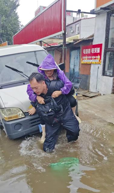 (260714) -- BEIJING, July 14, 2026 (Xinhua) -- A police officer transfers a stranded resident in Shenyang, northeast China's Liaoning Province, July 13, 2026. Torrential rain has caused flooding in multiple places in China recently. In rescue across the country, rescuers have risen to the occasion to protect the people. (Photo by Zou Xinjiang/Xinhua)