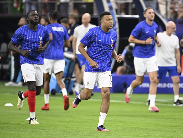 (260715) -- DALLAS, July 15, 2026 (Xinhua) -- Kylian Mbappe (R, front) of France warms up before the semifinal match between France and Spain at the 2026 FIFA World Cup at Dallas Stadium in Dallas, the United States, July 14, 2026. (Xinhua/Chen Yichen)