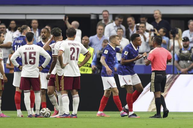 (260715) -- DALLAS, July 15, 2026 (Xinhua) -- Kylian Mbappe (2nd R) of France communicates with the referee as Adrien Rabiot (2nd L) of France is shown a yellow card during the semifinal match between France and Spain at the 2026 FIFA World Cup at Dallas Stadium in Dallas, the United States, July 14, 2026. (Xinhua/Xu Zijian)