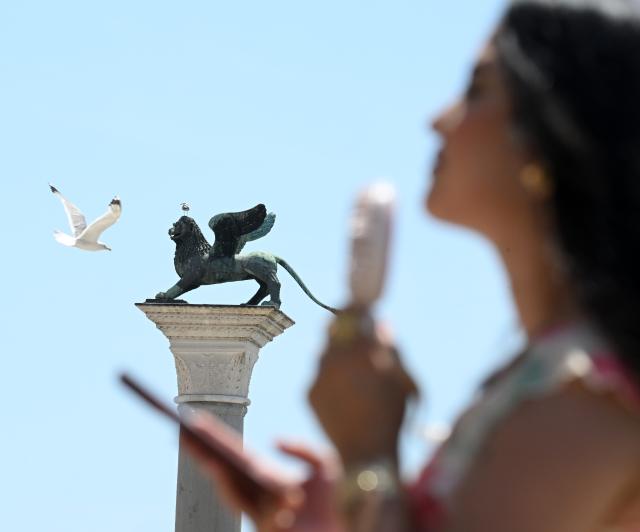 (260714) -- VENICE, July 14, 2026 (Xinhua) -- A tourist uses a portable fan to cool off at San Marco Square in Venice, Italy, on July 14, 2026. (Photo by Alberto Lingria/Xinhua)