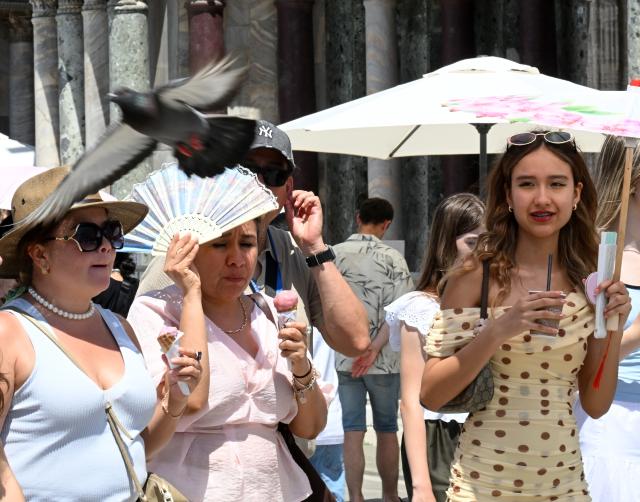 (260714) -- VENICE, July 14, 2026 (Xinhua) -- Tourists eat gelato to cool off at San Marco Square in Venice, Italy, on July 14, 2026. (Photo by Alberto Lingria/Xinhua)