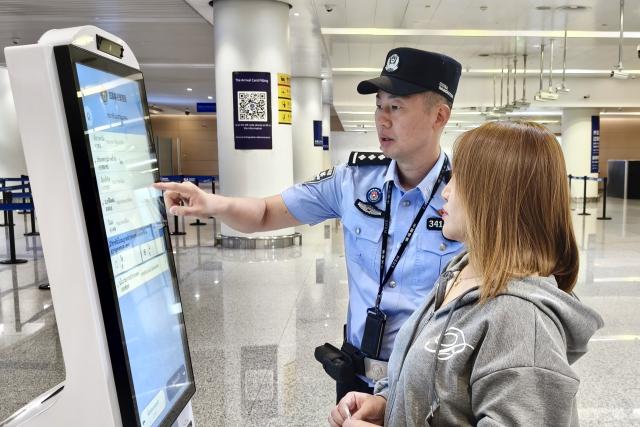 (260715) -- BEIJING, July 15, 2026 (Xinhua) -- A police officer helps a Thai passenger with entry registration at Chongqing Jiangbei International Airport in southwest China's Chongqing Municipality, July 13, 2026. Since the beginning of this year, inbound and outbound passenger traffic at Chongqing Jiangbei International Airport has continued to grow, with a significant increase in foreign passenger traffic. In the first half of 2026, the airport handled more than 1.48 million inbound and outbound passenger trips, up 39.5 percent year on year. (Photo by Zeng Yanyan/Xinhua)