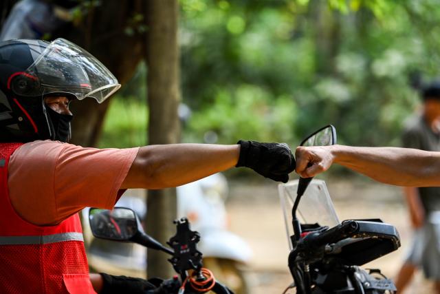 (260715) -- BEIJING, July 15, 2026 (Xinhua) -- A volunteer (L) and a rescuer bump fists in Yunbiao Town, Hengzhou City, south China's Guangxi Zhuang Autonomous Region, July 14, 2026. Efforts are underway to support flood relief and recovery in Guangxi, which has been hit by severe rainstorms and flooding caused by Typhoon Maysak. (Xinhua/Cao Yiming)