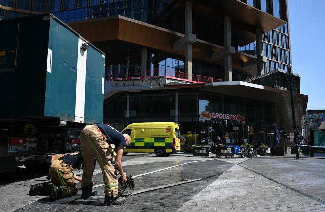 (260715) -- BEIJING, July 15, 2026 (Xinhua) -- Firefighters work near the fire site of the Oxy building on De Brouckere Square, Brussels, Belgium, July 14, 2026. Multiple people have died on Tuesday in a fire at the well-known Oxy building on De Brouckere Square, in the center of Brussels.
   According to local media, 6 people are still missing. The fire brigade has deployed en masse for a major search and rescue operation. (Xinhua/Peng Ziyang)