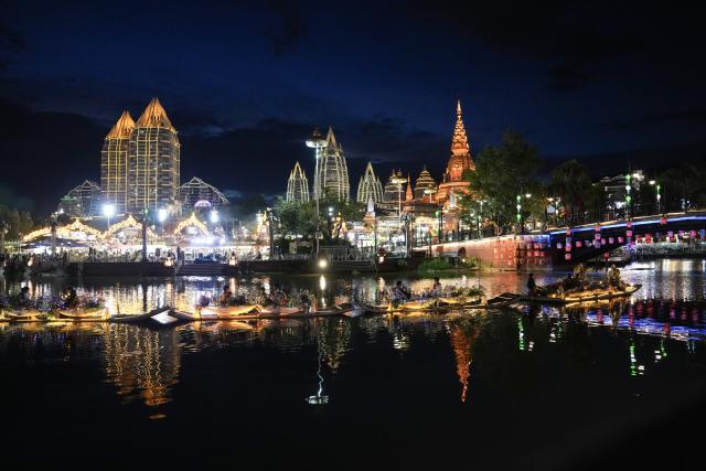 (260715) -- XISHUANGBANNA, July 15, 2026 (Xinhua) -- Tourists take boats to visit the Starlight Night Market in Jinghong, Xishuangbanna Dai Autonomous Prefecture, southwest China's Yunnan Province, July 14, 2026. The Starlight Night Market, located in Jinghong of Xishuangbanna Dai Autonomous Prefecture, has witnessed a surge in visitor arrivals during the summer peak tourism season. Featuring local delicacies, ethnic culture and diverse nighttime consumption options, this night market reflects the vitality of local cultural and tourism market. (Xinhua/Chen Xinbo)