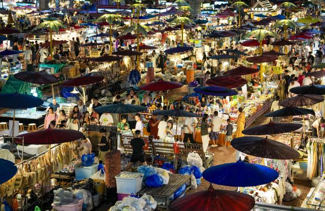 (260715) -- XISHUANGBANNA, July 15, 2026 (Xinhua) -- This photo taken on July 14, 2026 shows a view of the Starlight Night Market in Jinghong, Xishuangbanna Dai Autonomous Prefecture, southwest China's Yunnan Province. The Starlight Night Market, located in Jinghong of Xishuangbanna Dai Autonomous Prefecture, has witnessed a surge in visitor arrivals during the summer peak tourism season. Featuring local delicacies, ethnic culture and diverse nighttime consumption options, this night market reflects the vitality of local cultural and tourism market. (Xinhua/Chen Xinbo)