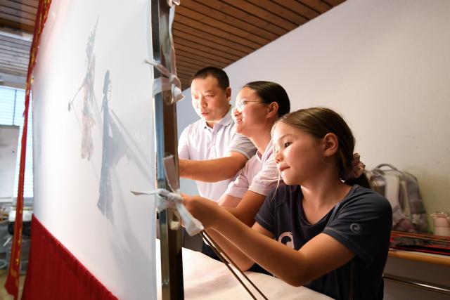 (260715) -- BERN, July 15, 2026 (Xinhua) -- Members of a Chinese culture summer camp try Chinese shadow puppetry in Bern, Switzerland, July 14, 2026. A summer camp featuring traditional Chinese culture opened here on Tuesday. (Xinhua/Lian Yi)
