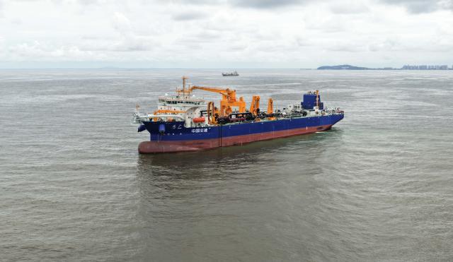 (260715) -- GUANGZHOU, July 15, 2026 (Xinhua) -- A drone photo taken on July 14, 2026 shows the "Junguang" dredger at the Beibu Gulf in south China's Guangxi Zhuang Autonomous Region. The "Junguang," a mega dredger with a 35,000 cubic meter capacity, was recently put into operation. Measuring 198 meters in length, with a maximum dredging depth of 120 meters and a deadweight of 60,483 tonnes, the vessel is the largest of its kind in Asia. 
  The vessel is equipped with the self-developed intelligent dredging control systems. It is capable of exceptional performance, including strong soil penetration, deep dredging, long-distance transport, and extended blowing capabilities. It is expected to be widely used in port and waterway dredging, deep-sea sand extraction, land reclamation, deep-sea mining, trench excavation and backfilling, gravel bed construction, and deep-sea pipeline laying. (Xinhua/Deng Hua)