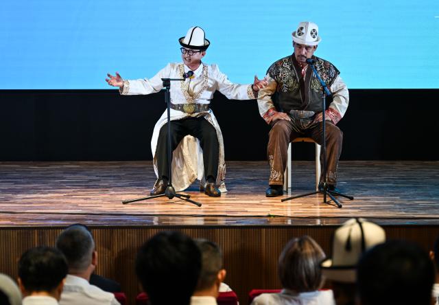 (260715) -- BISHKEK, July 15, 2026 (Xinhua) -- Participants listen to the performance of Kyrgyz epic Manas at the 2026 Shanghai Cooperation Organization (SCO) Dialogue of Civilizations in Bishkek, the capital of Kyrgyzstan, July 14, 2026. The event was held on Tuesday in Bishkek, where around 200 representatives from governments, media, cultural institutions and academia across SCO member states underscored the importance of dialogue and mutual learning among civilizations. (Xinhua/Li Renzi)